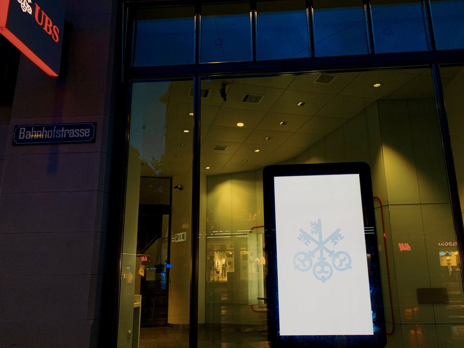 Un bancomat e la sede di UBS a Zurigo (foto illustrativa)