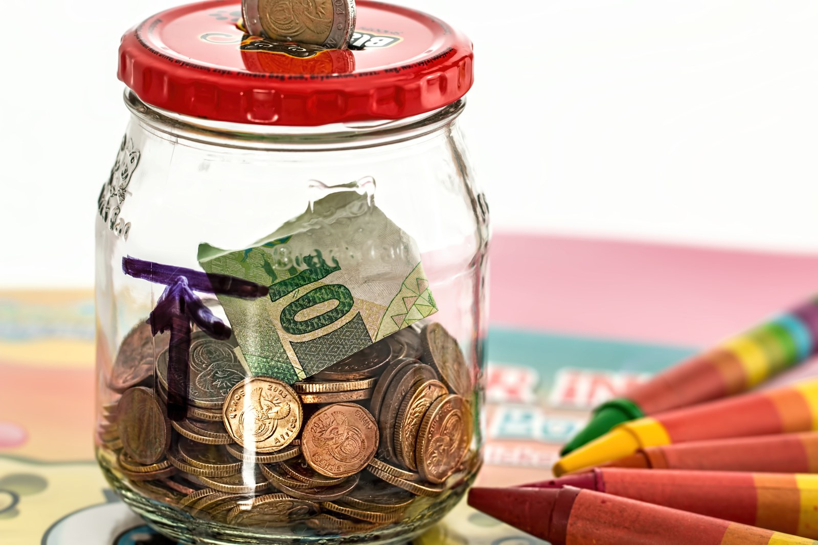Barattolo di risparmio e monete (foto illustrativa).