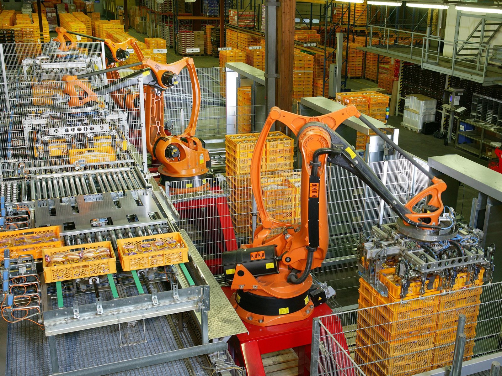 Bracci robotici industriali in funzione in un impianto di produzione.